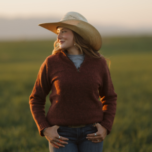 Woman wearing Ladies Mae Wool Sweater Wild Plum in field