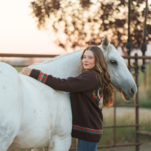 Woman wearing Ladies Rose Wool Cardigan Dark Chocolate beside horse