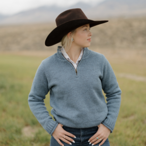 Woman wearing Ladies Mae quarter zip wool sweater chambray blue in field