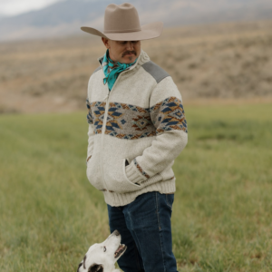 Man wearing Charleston wool sweater jacket stone in field with border collie